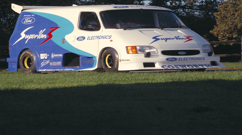 Ford Supervan3 parked on grass with wooden rail fence behind