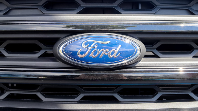 Close-up of the Ford logo on the grill of a bright blue vehicle