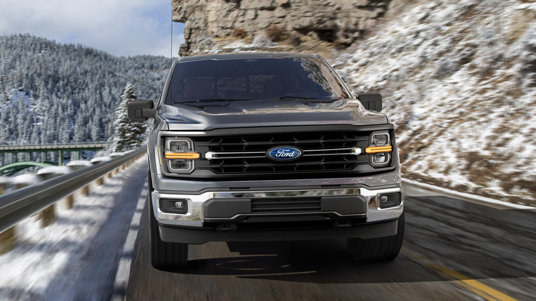 Front view of the 2025 Ford F-150 driving on a snowy mountain pass