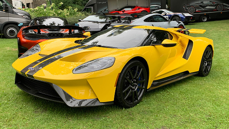 Front 3/4 view of yellow modern Ford GT parked on display at car show.