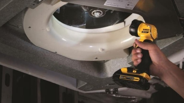 Person looking at underside of machine with DeWalt 20V Max LED Work Light/Flashlight