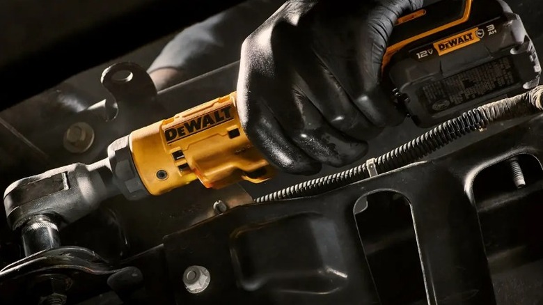 Person removing bolt with DeWalt Xtreem 12V Max Variable Speed Brushless ⅜-inch Drive Ratchet Wrench