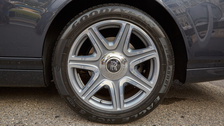 A close-up of a gray Rolls Royce wearing Goodyear tires.