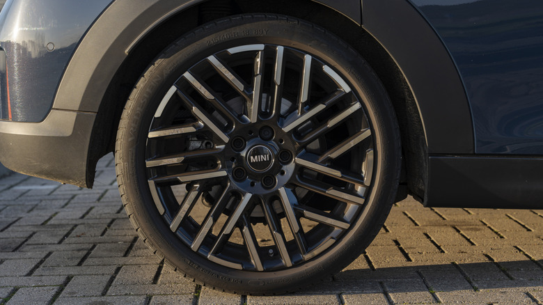 A close-up of a gray Mini Cooper wearing Vredestein tires.