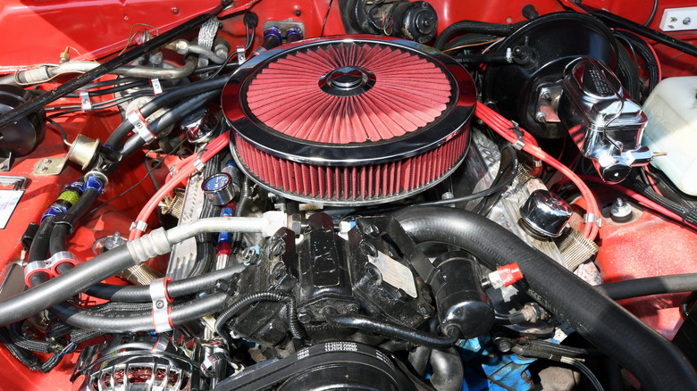 A close-up of a 1970s Plymouth engine bay featuring a muscle car V8.