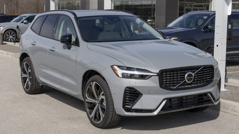 A dark gray Volvo XC 60 T8 parked in front of a dealership.