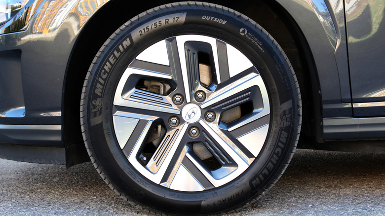 A close-up of a clean gray passenger vehicle wearing a Michelin tire on the front left corner.