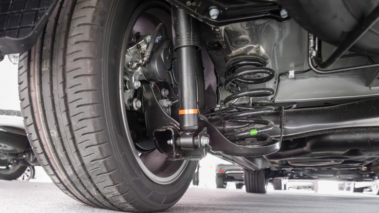 Rear tire and suspension all in black under a car