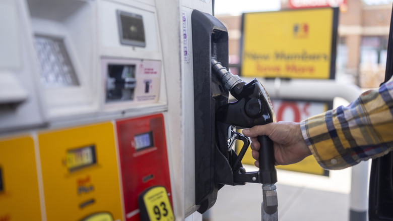Hand putting gas pump back in place