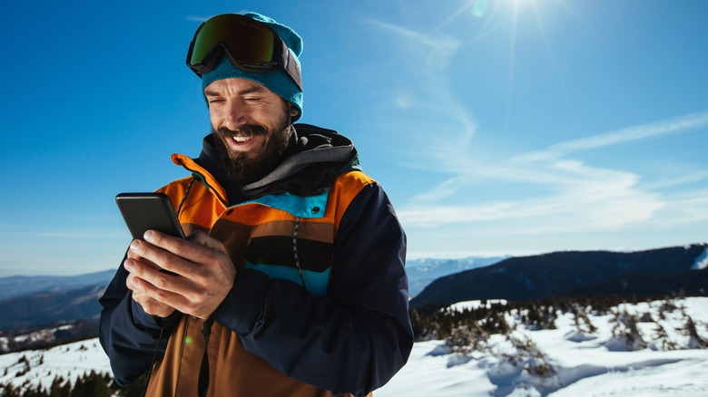 A skier checking his phone