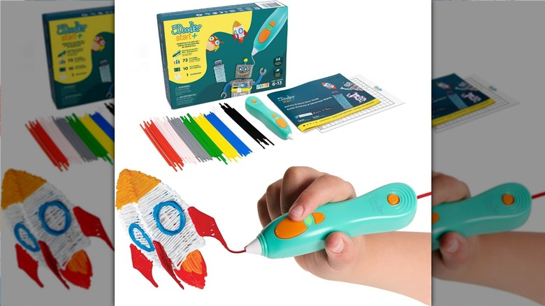 Hand using a 3D printing pen with accessories in the background