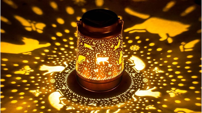 Glowing lamp with cutout patterns of cats