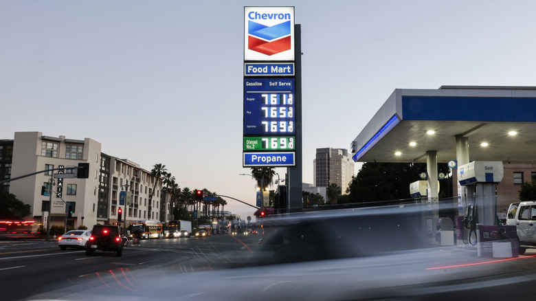 Car passing in front of gas station sign in California