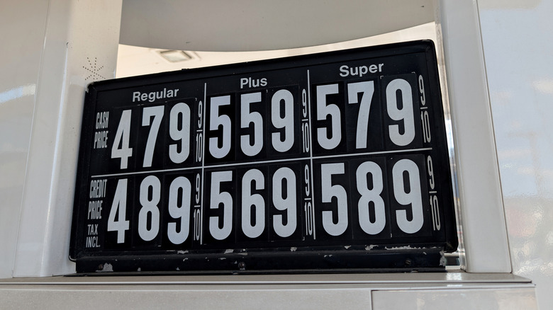 A sign on a gas pump displaying prices.