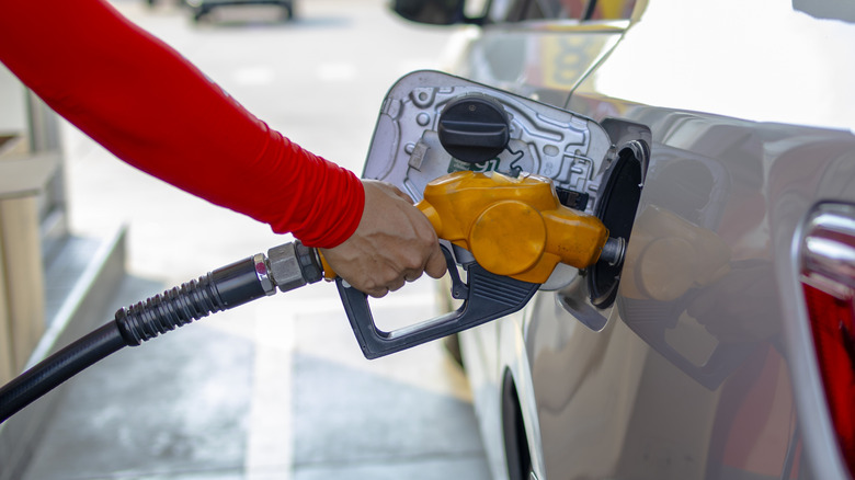 A person refuels car at gas station