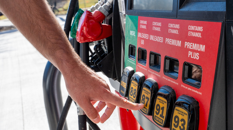 Male hand selecting 87-octane gasoline at US gas station