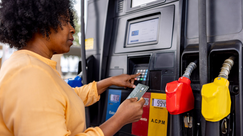Close up of a person making a card payment at a gas pump.