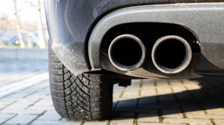 A twin exhaust pipe shown at the rear of a modern passenger vehicle