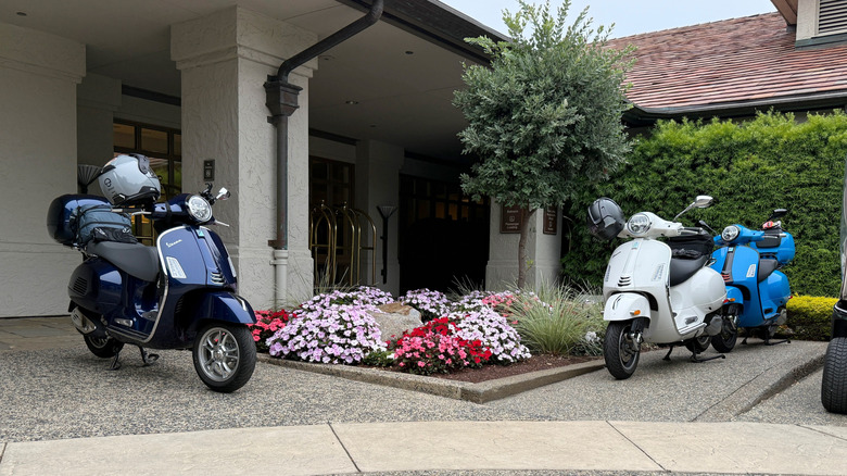 A group of Vespa 310 scooters parked at a hotel