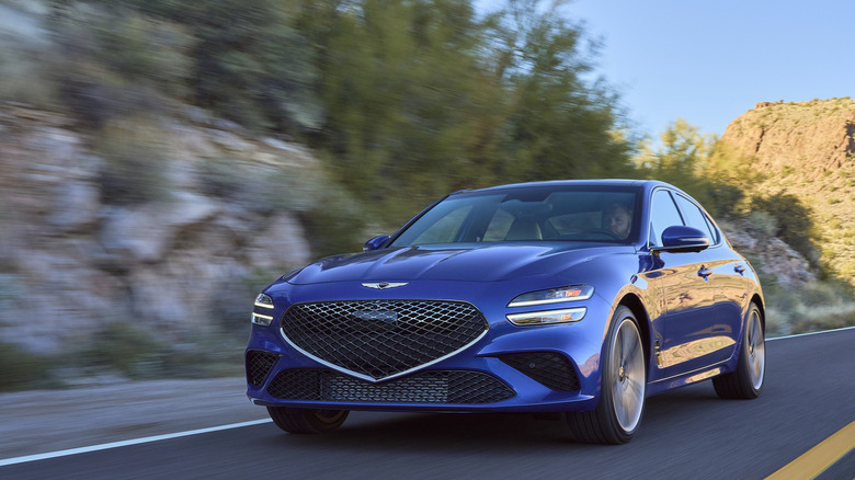 Blue Genesis G70 3.3T driving on a mountain road