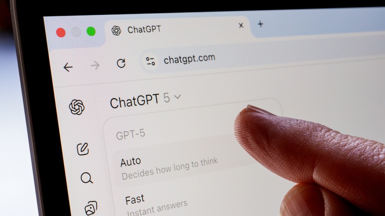 Finger pointing at ChatGPT interface on laptop