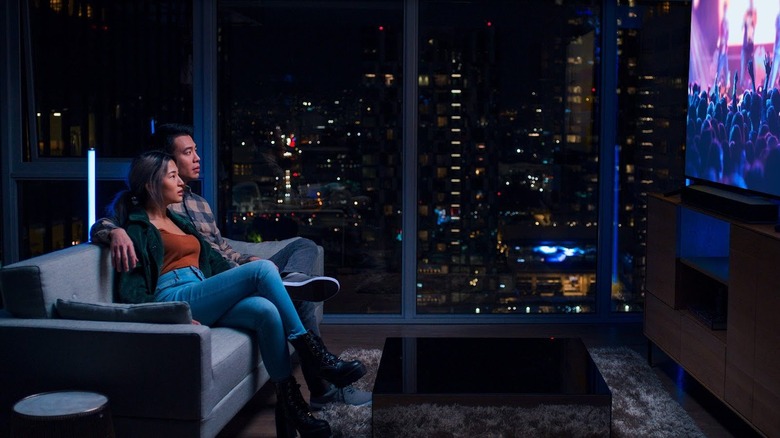 Couple watching a large-screen TV in living room