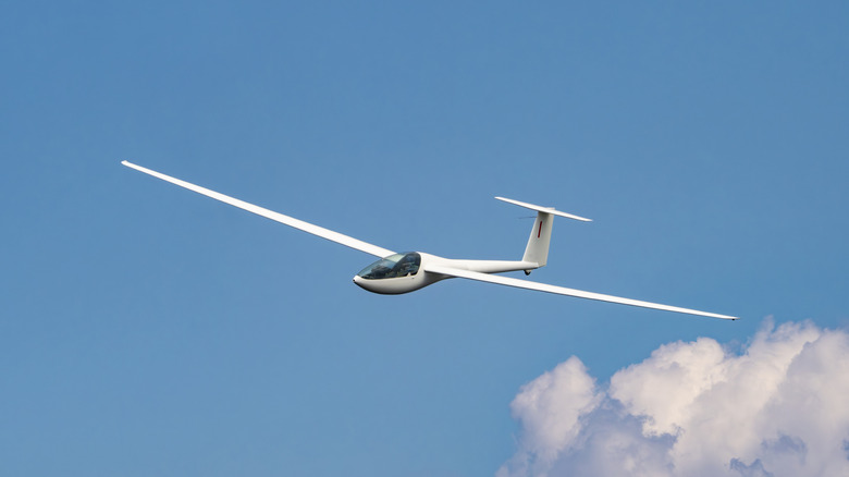 A glider in flight under blue skies