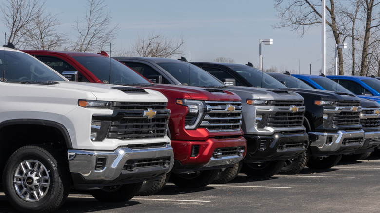 Chevrolet Silverado trucks parked at a General Motors dealership.