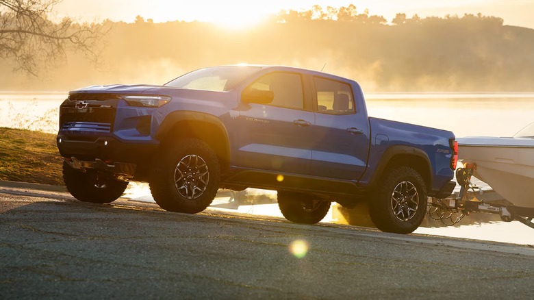 A blue Chevy Colorado on a boat ramp in the evening.