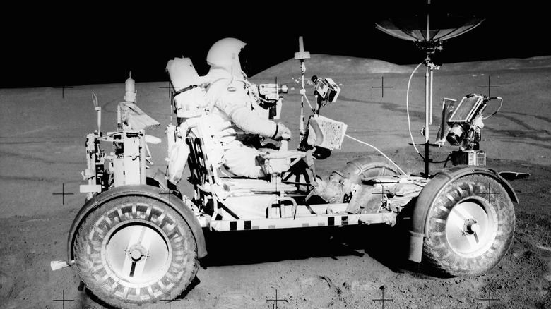 Side view of Lunar Buggy on Moon with astronaut driving