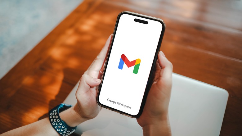 hands holding phone with gmail logo