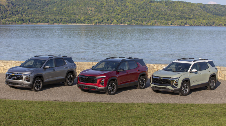 Silver, red, and green Chevrolet Equinox SUVs parked next to a lake
