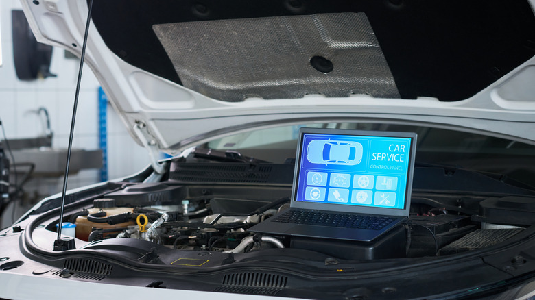 Running an engine diagnostics test via a software on a  laptop.