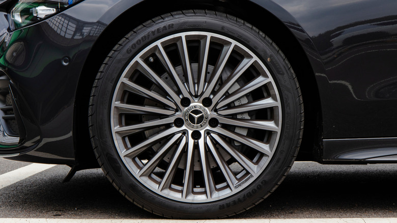 A black Mercedes luxury sedan wearing a Goodyear tire.