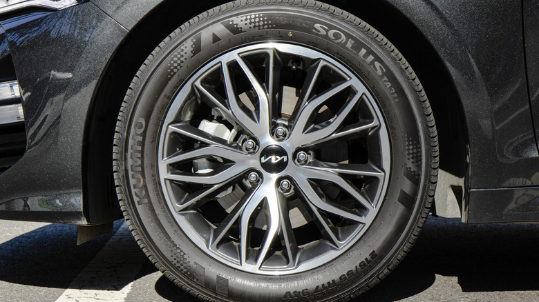 A Kia K5 sedan wearing a Kumho tire.