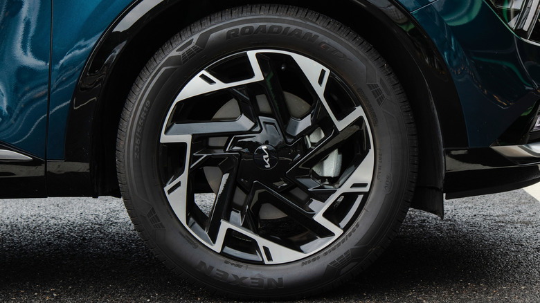 A dark blue Kia Sportage SUV waring Nexen tires.