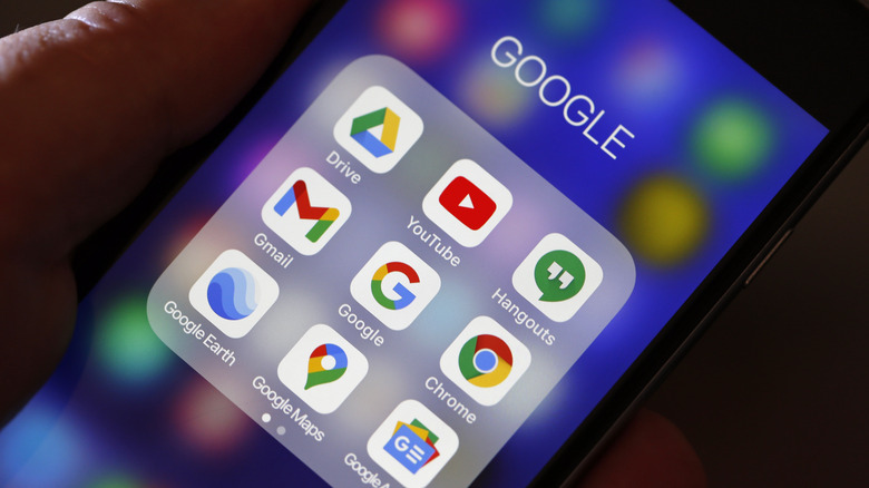 hand holding phone with Google apps