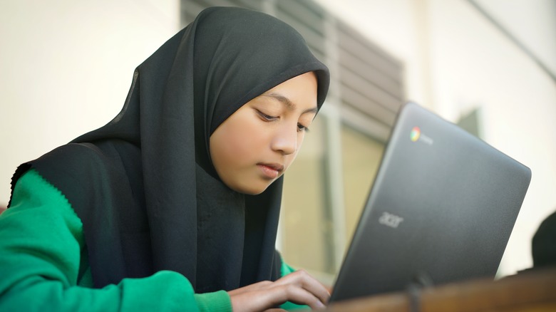 young girl using Chromebook