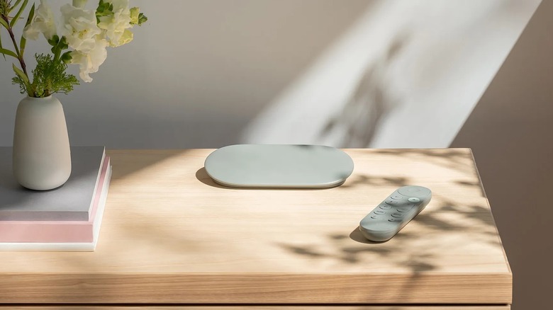 Google TV Streamer with remote on a table next to vase of flowers