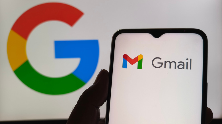Gmail logo on phone against Google logo in background