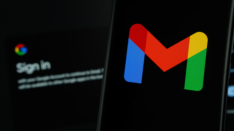 Gmail logo on smartphone with Google login screen in background