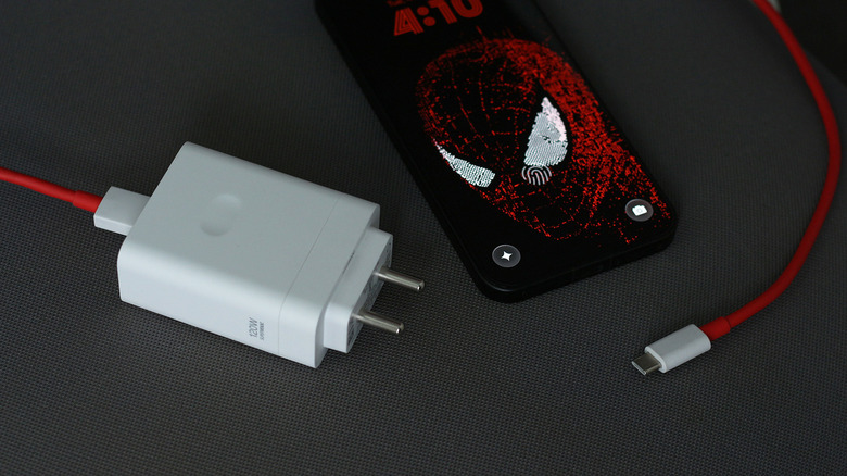 A OnePlus phone next to its charger