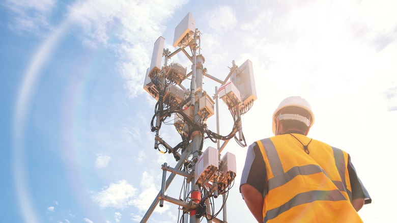 worker looking up at 5g antenna