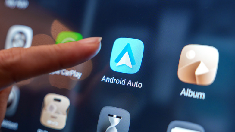 Close-up of a user interacting with Android Auto on a car display