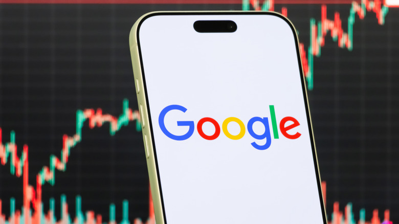 google on a phone screen with stocks behind it
