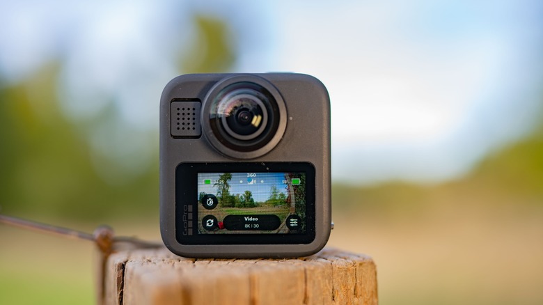 GoPro Max 2 on top of  a fence post with the screen turned on.
