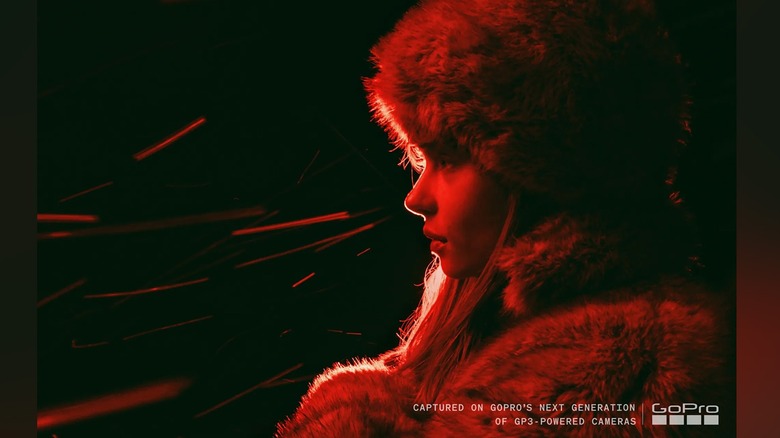 A high contrast image of a woman lit by a red light.