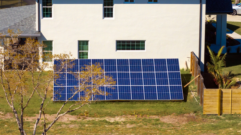 Solar panels mounted on the ground in front of house
