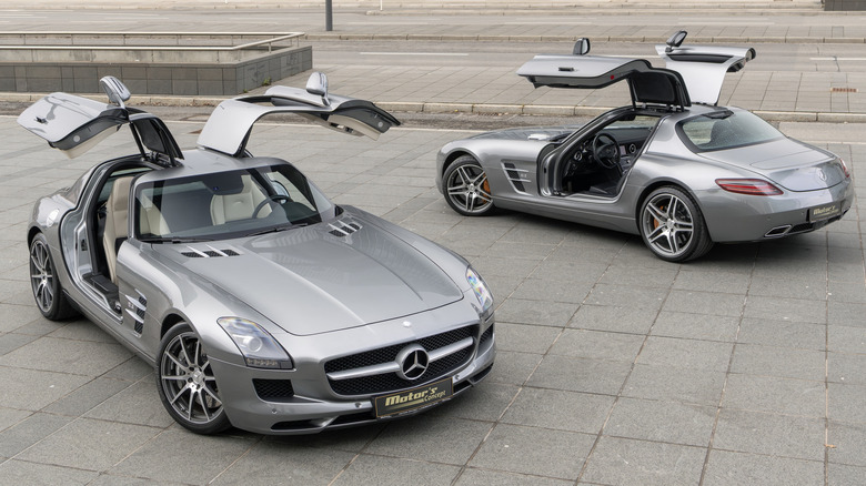 Two Mercedes-Benz SLS AMG cars with their gullwing doors open