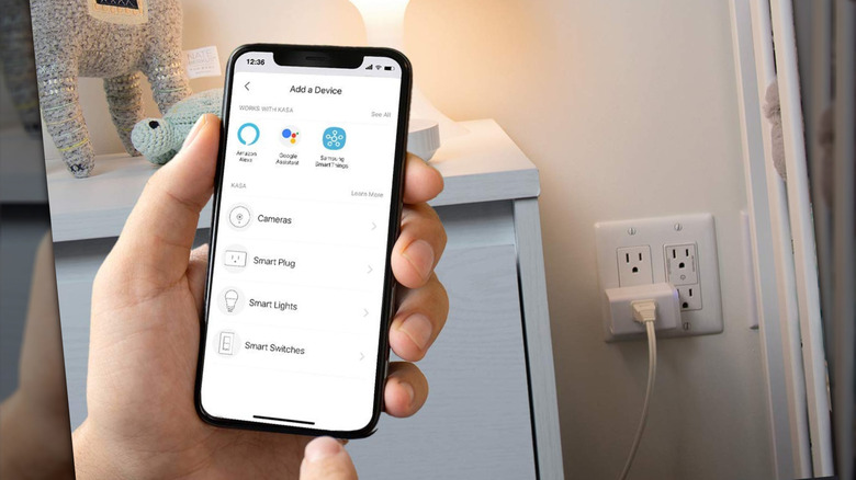 A person about to press a menu button with a smart plug in the background.